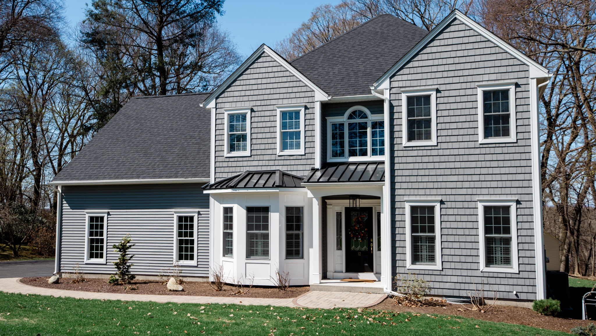 Beautiful two-story home featuring new blue vinyl siding, white shutters, and upgraded curb appeal.