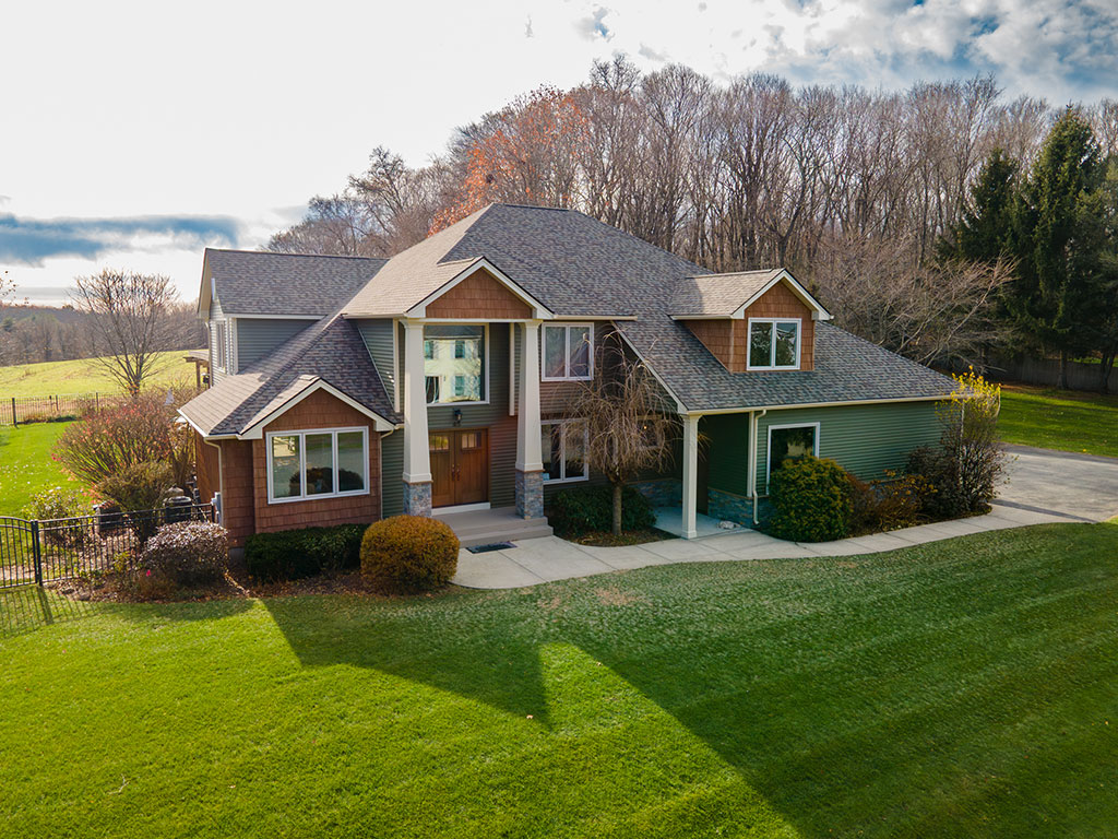 ThermaTru by Reeb Fiber Classic entry doors stained in Acorn color. Landmark Pro Weathered Wood Roof. Mastic Carvedwood siding. Mastic Cedar Discovery shake-style siding. Clapbard siding color is Lakeshore Fern. Cultured stone knee wall.